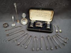 A George V silver three piece cruet set, Sheffield, 1919, cased together with a silver napkin ring,