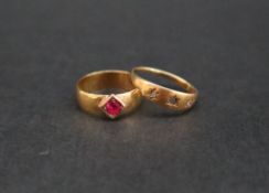 A yellow metal band, set with a round faceted ruby, together with a yellow metal gypsy ring,