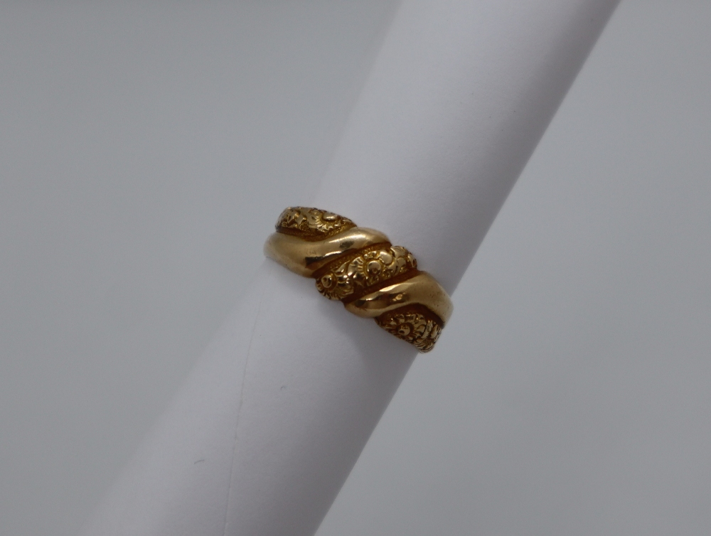 An 18ct yellow gold ring, cast with flowerheads,