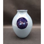 A Moorcroft pottery vase decorated with royal blue vignettes of flowers and leaves to a light blue