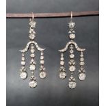 A pair of diamond drop earrings, set with graduating cushion cut diamonds to a white metal setting,
