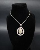 A diamond pendant set with a central fancy yellow pear shaped diamond approximately 12mm x 8mm