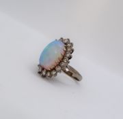 An opal and diamond ring, the central oval opal, chipped,