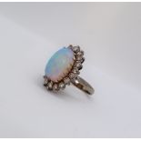 An opal and diamond ring, the central oval opal, chipped,