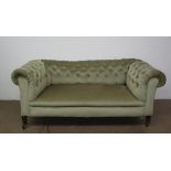 A Victorian drop arm Chesterfield settee on turned legs and casters,