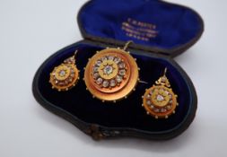 A Victorian yellow metal and diamond set brooch of circular form set with a central cushion cut