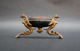 A 19th century gilt and ebonised pen wipe/pin cushion, with winged Griffing supports, 11cm long x 5.