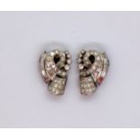 A pair of diamond encrusted earrings, set with round brilliant and baguette diamonds,