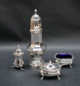 A George VI silver sugar castor with a flame finial and pierced top above a panelled baluster body