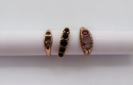 A 9ct gold garnet set ring, together with two other 9ct gold rings,