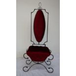 A wrought iron upholstered chair, with a rectangular back and oval pad,