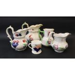 A Swansea pottery pouch jug decorated with sprays of garden flowers together with three other