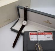 A lady's Omega De Ville wristwatch, the white dial with Roman numerals, on a leather strap,