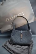 A Gucci handbag with leather strap and base and black material body,