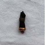 An African ebony pendant in the form of a hand with forearm, and bracelets, yellow metal base,