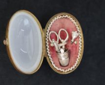 A late 19th century opaline etui, of egg shape with gilt metal mount, enclosing a pair of scissors,