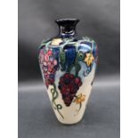 A Moorcroft pottery vase decorated with bunches of grapes and leaves to a cream ground,