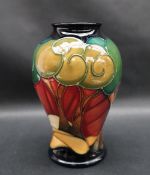 A Moorcroft pottery vase decorated with a sunrise behind trees, impressed marks, dated 2005,