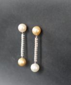 A pair of diamond and pearl drop earrings, set with a large yellow and white pearl,