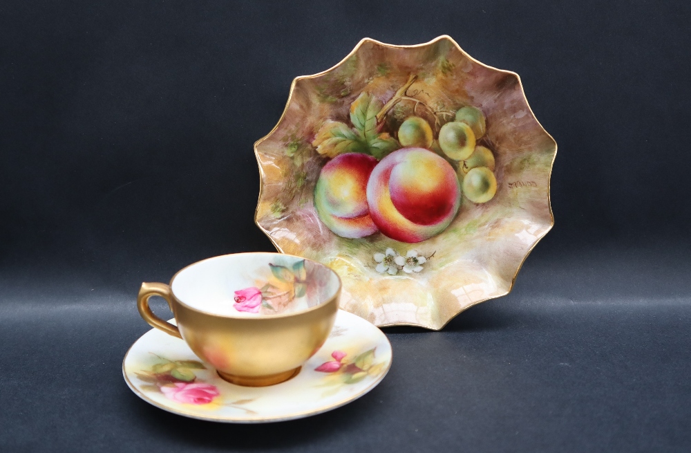 A Royal Worcester cabinet cup and saucer painted with a pink rose and rose buds,