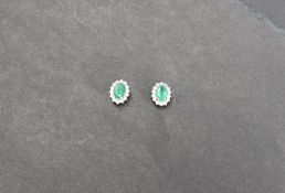 Gemporia - a pair of 9ct gold emerald and diamond cluster earrings