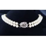 A double strand pearl necklace set with one hundred and twenty one regular pearls to a white metal