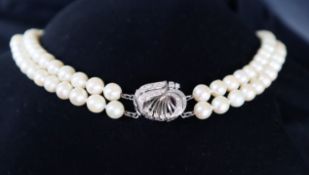 A double strand pearl necklace set with one hundred and twenty one regular pearls to a white metal