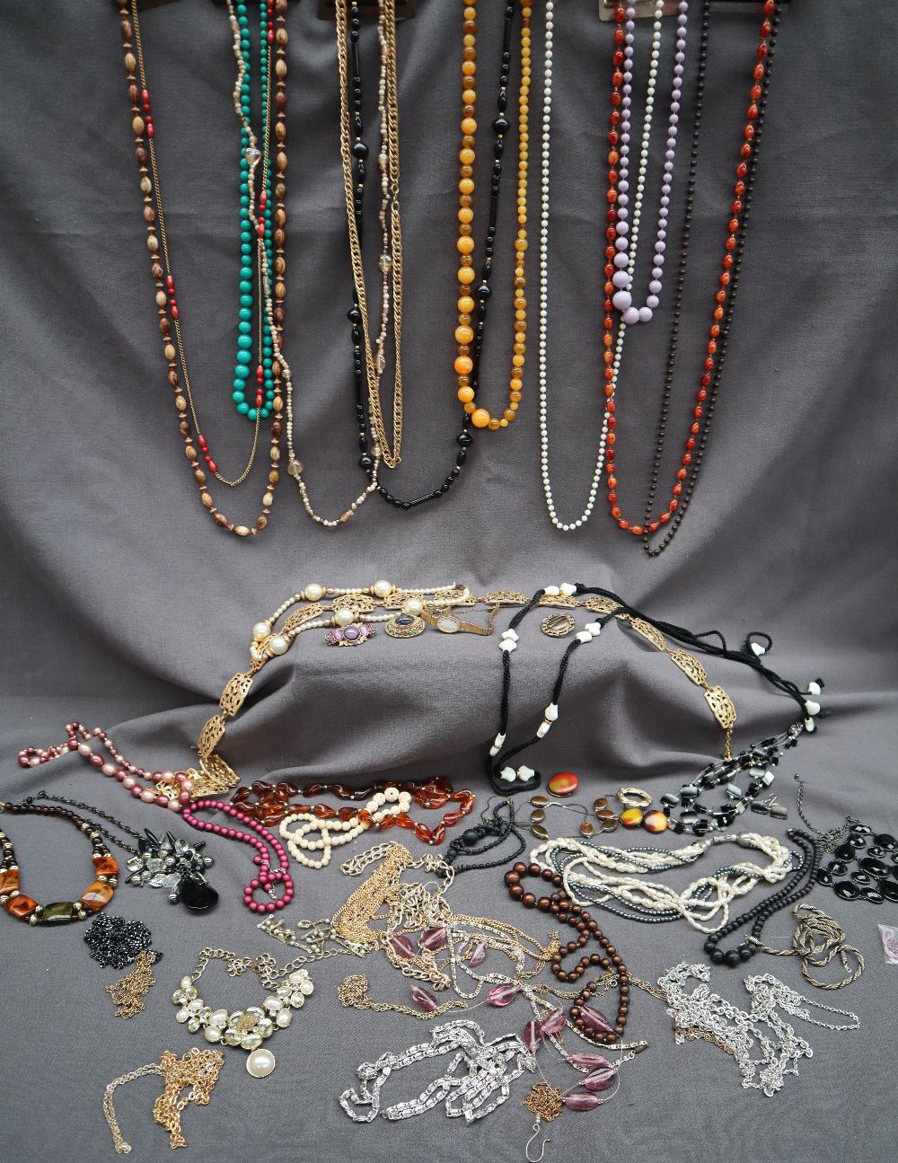 A collection of costume jewellery including beaded necklaces, brooches,