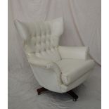 A mid 20th century cream leatherette egg chair, with a button upholstered back,