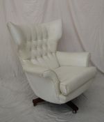 A mid 20th century cream leatherette egg chair, with a button upholstered back,