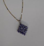 Gemporia - A tanzanite set pendant of diamond shape set with multiple pear shaped tanzanites to a