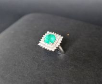 An emerald and diamond dress ring, the cushion cut emerald approximately 9mm x 9mm,