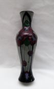 A Moorcroft pottery slender vase decorated with flowers to a grey ground,