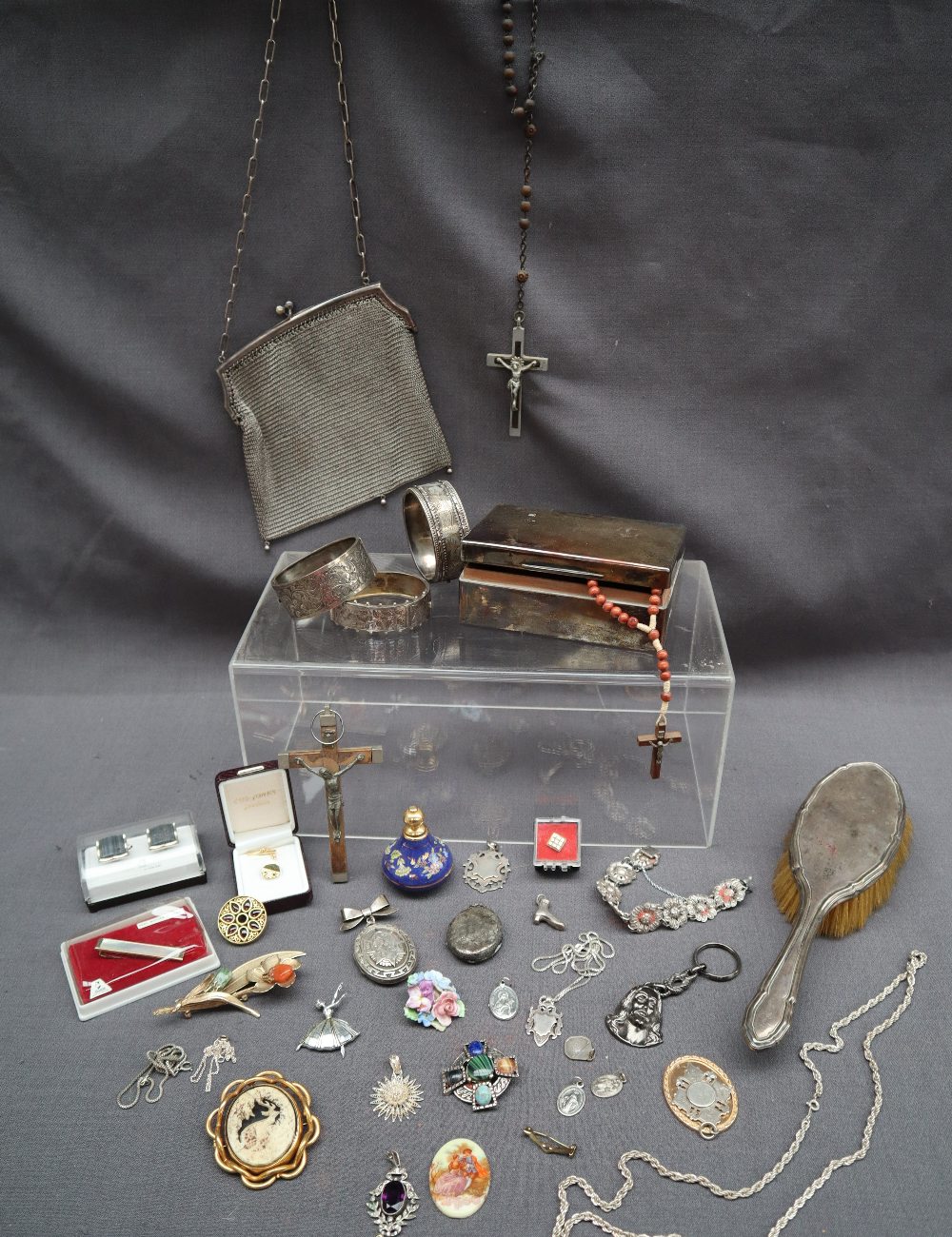 A silver backed mirror, together with a silver cigarette box, silver bangles, silver medallions,