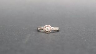 A 9ct white gold diamond set halo ring, the central round old cut diamond approximately 0.