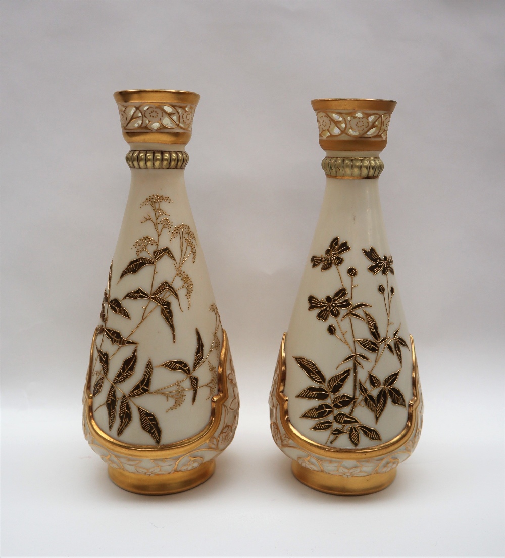 A pair of Royal Worcester porcelain vase with a pierced flared top above a tapering body decorated