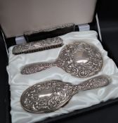 An Elizabeth II silver dressing table set, comprising a hand mirror, hair brush and clothes brush,