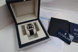 A lady's Corum wristwatch, of rectangular stepped form, with a black dial,