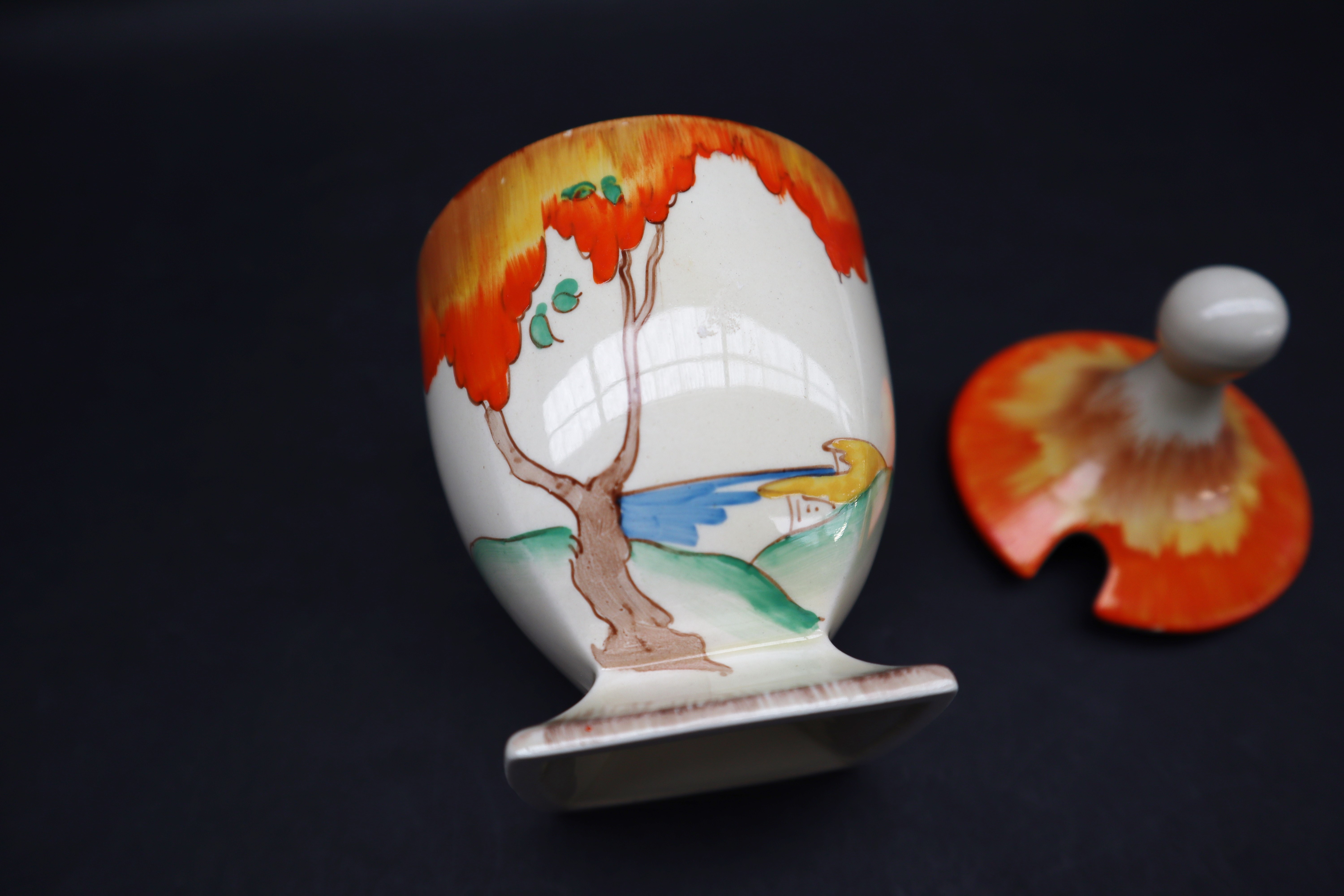 A Clarice Cliff preserve pot and cover, painted with an orange tree and coastal landscape beyond, - Image 2 of 5