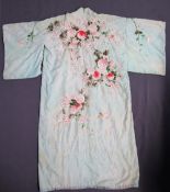 A Japanese silk kimono with embroidered decoration of flowers and leaves to a green ground