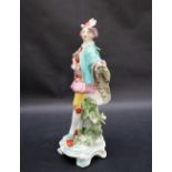 A Derby porcelain figure in a tricorn hat and turquoise cape holding a spray of garden flowers