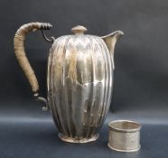 An Edward VII silver hot water pot of elongated melon shape decorated with swags and flowerheads to