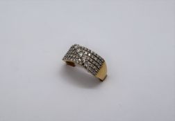 An 18ct gold ring set with five lines of round brilliant cut diamonds with a band of five round
