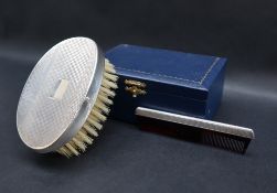 A modern silver backed clothes brush and matching comb, dated 2000,