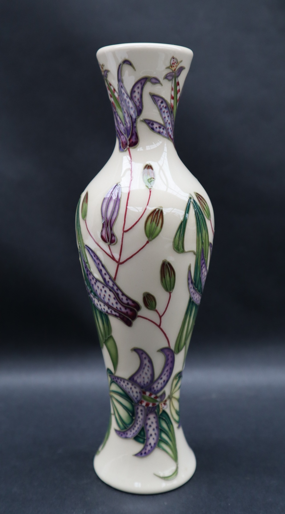 A Moorcroft pottery vase of baluster form decorated with purple tiger lilies, impressed marks,