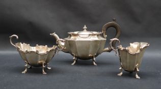 A George V silver three piece tea set, of panelled oval form, on scrolling feet, Birmingham, 1922,