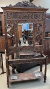 A late 19th century low countries oak hall stand, with a mask carving, mirror and dragons,