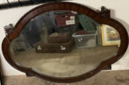 A mahogany framed wall mirror of shaped oval form