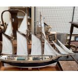 A model ship, with three masts and unfurled sails, bears a plaque for Jane Banks, Bideford,