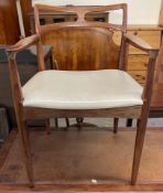 A mid 20th century Danish elbow dining chair with a pierced back and pad seat on tapering legs